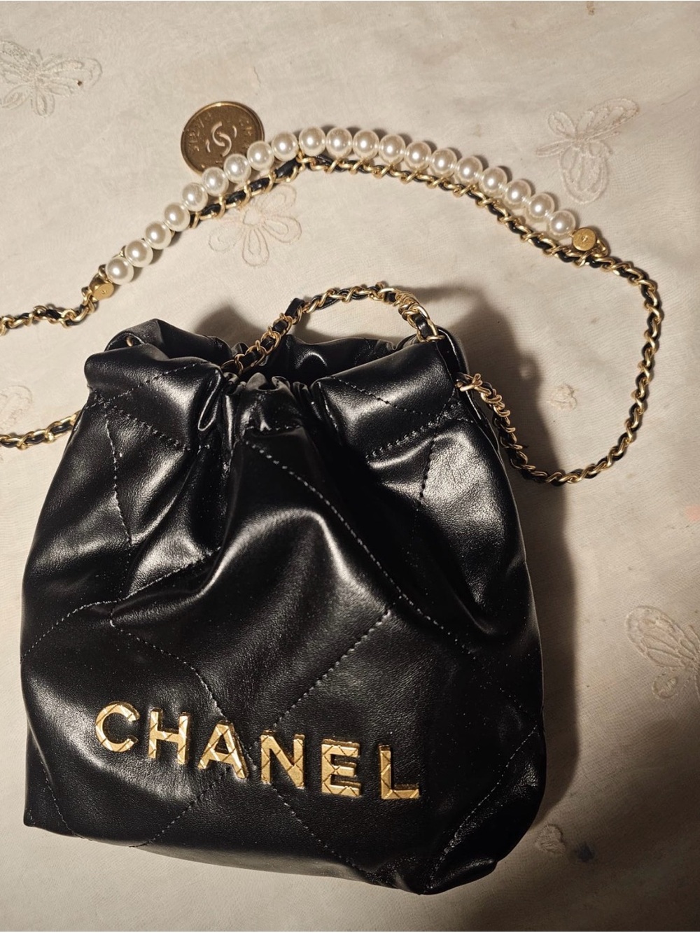CHANEL Black Quilted Drawstring Mini Bag with Pearl-Trim Chain